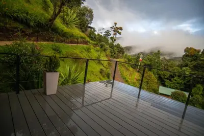 a wooden deck with a view of a mountain at Hotel de Montaña Gema del Bosque in El Copey