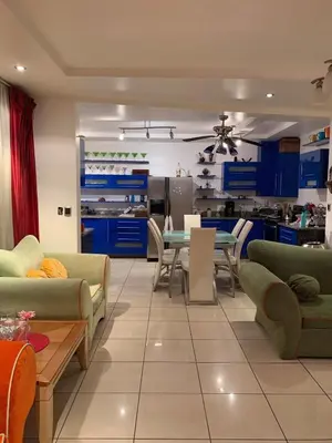 a living room with blue cabinets and a table and chairs at Modern Mediterranean Santorini House in Cartago