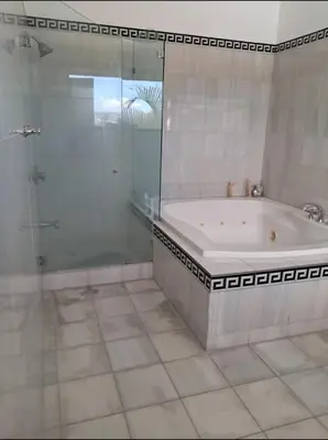 a bathroom with a tub and a glass shower at Modern Mediterranean Santorini House in Cartago