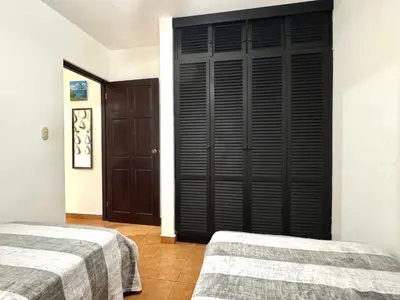 a bedroom with two beds and a black door at Condo Morpho with 2bed 2 baths in Coco