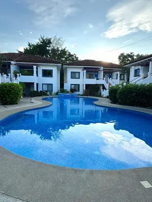 a large blue swimming pool in front of a house at Condo Morpho with 2bed 2 baths in Coco