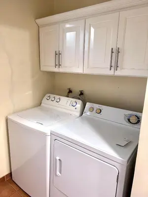 a white washer and dryer in a kitchen with white cabinets at Three Bedroom Spacious Townhome in Coco
