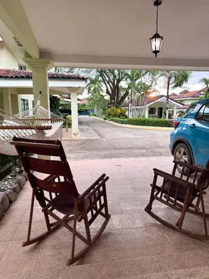 two chairs and a hammock on a porch with a car at Three Bedroom Spacious Townhome in Coco