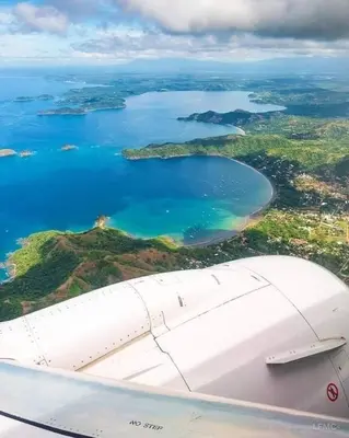 a view from the wing of an airplane flying over a body of water at Three Bedroom Spacious Townhome in Coco