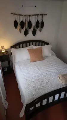a bed with a white comforter and pillows at Casita Thisa Chibú in Bijagua