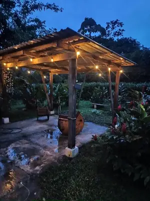 a wooden pergola in a garden at night at Casita Thisa Chibú in Bijagua