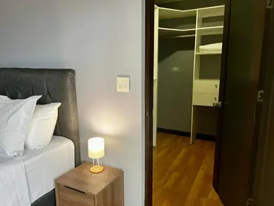 a bedroom with a bed and a table with a lamp at Apartment in La Sabana in San José