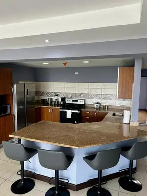 a large kitchen with a large island with bar stools at Apartment in La Sabana in San José