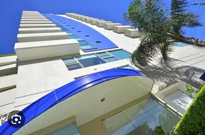 a large building with a palm tree in front of it at Apartment in La Sabana in San José