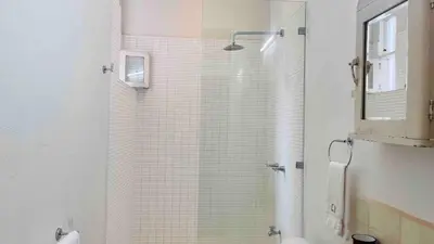 a bathroom with a shower with a glass door at Casa Botánica de Aranjuez in San José