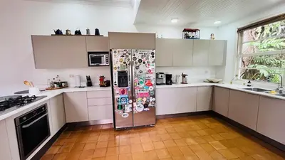 a kitchen with a refrigerator with stickers on it at Casa Botánica de Aranjuez in San José