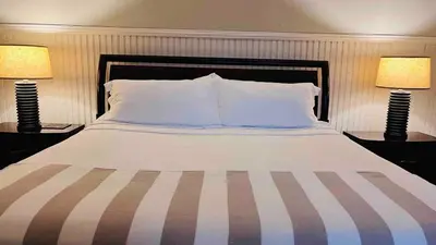 a bedroom with a large bed with two lamps at Casa Botánica de Aranjuez in San José