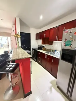 a kitchen with red cabinets and a stainless steel refrigerator at Casa residencial en playa Herradura in Herradura