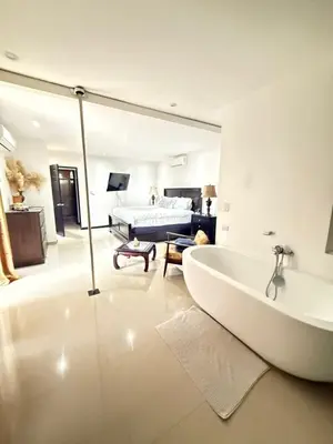 a large bathroom with a tub and a bedroom at Casa residencial en playa Herradura in Herradura