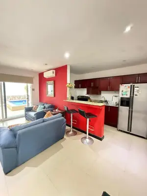 a living room with a blue couch and a kitchen at Casa residencial en playa Herradura in Herradura