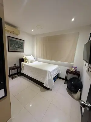 a bedroom with a bed with a window and two tables at Casa residencial en playa Herradura in Herradura