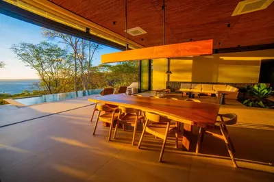 a dining room with a wooden table and chairs at Casa Lagom, Luxurious Oasis with Infinity Pool! in La Cruz