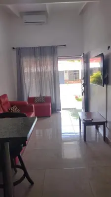 a living room with a red couch and a table at Villas jaco costa rica in Jacó