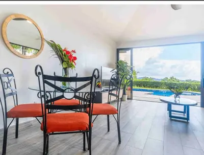 a dining room with a table and chairs and a balcony at Ocean Views-Private-Pool-Easy access-Ojochal-Gate in Ojochal