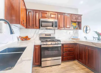 a kitchen with wooden cabinets and a stove top oven at Ocean Views-Private-Pool-Easy access-Ojochal-Gate in Ojochal