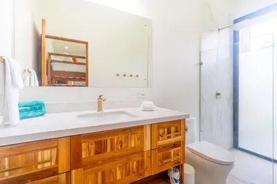 a bathroom with a sink and a toilet and a mirror at NEW! Luxury-4 Suites-Private pool-Ocean views in Coronado