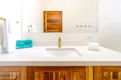 a bathroom with a white sink and a mirror at NEW! Luxury-4 Suites-Private pool-Ocean views in Coronado