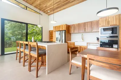 a kitchen with wooden cabinets and a table and chairs at NEW! Luxury-4 Suites-Private pool-Ocean views in Coronado