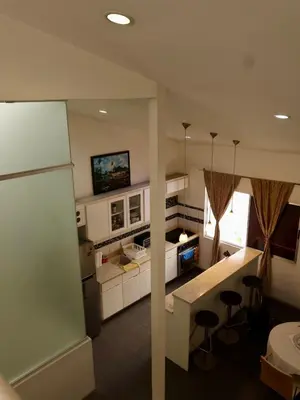 a kitchen with white cabinets and a counter top at Amá in Puerto Limón