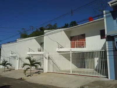 a white house with a fence in front of it at Amá in Puerto Limón