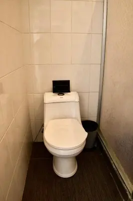 a bathroom with a white toilet with a black seat at Amá in Puerto Limón
