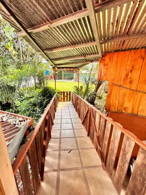 a wooden walkway with a wooden pergola at Ecos del Poás vista a la montaña in Dulce Nombre