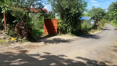 an empty road with a gate on the side of the road at Ecos del Poás vista a la montaña in Dulce Nombre