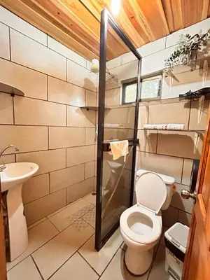 a small bathroom with a toilet and a sink at Ecos del Poás vista a la montaña in Dulce Nombre