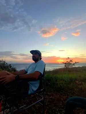a man sitting in a chair watching the sunset at Casa Abierta Playa Juquillal 2 habitaciones in Santa Cruz