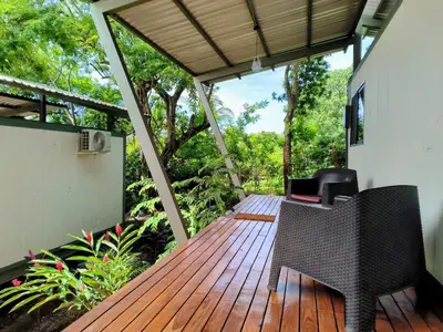 a wooden deck with a chair on a house at Casa Abierta Playa Juquillal 2 habitaciones in Santa Cruz