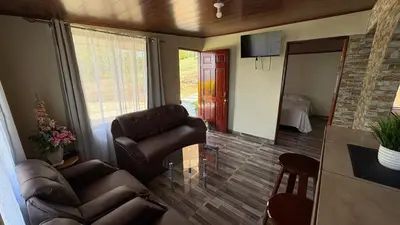 a living room with leather chairs and a glass table at Skyline Great View in Naranjo