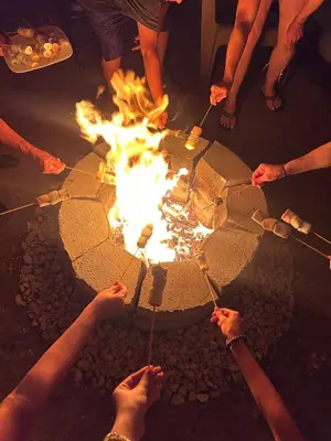 a group of people standing around a fire pit at Skyline Great View in Naranjo