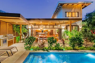 a house with a swimming pool in front of a house at Casa Cheetah Gated Luxury Villa with Guest House in Tamarindo