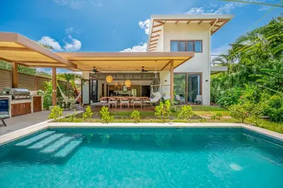a swimming pool in front of a house at Casa Cheetah Gated Luxury Villa with Guest House in Tamarindo