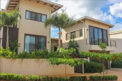 a house with palm trees in front of it at Casa Cheetah Gated Luxury Villa with Guest House in Tamarindo