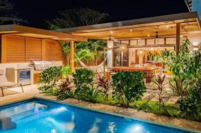 a backyard with a swimming pool and a house at Casa Cheetah Gated Luxury Villa with Guest House in Tamarindo