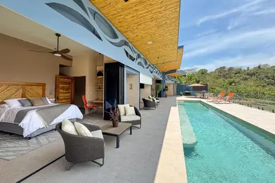 a bedroom with a bed and a swimming pool at Villa Buddha Belly OceanMountain top views in Quepos