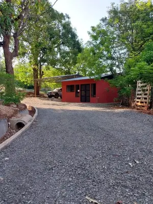 a red building with a car parked in front of it at Casa Abierta Playa Juquillal 1 habitacion in Santa Cruz