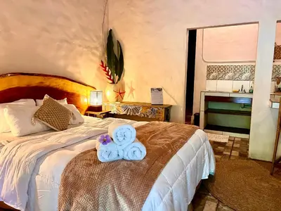a bedroom with a bed with a teddy bear on it at Kika Zaru Free MA Park Tour & Breakfast in Manuel Antonio