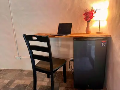 a desk with a laptop and a chair with a television at Kika Zaru Free MA Park Tour & Breakfast in Manuel Antonio
