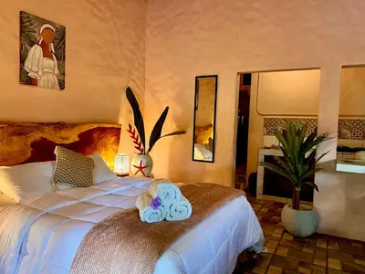 a bedroom with a bed with two towels on it at Kika Zaru Free MA Park Tour & Breakfast in Manuel Antonio