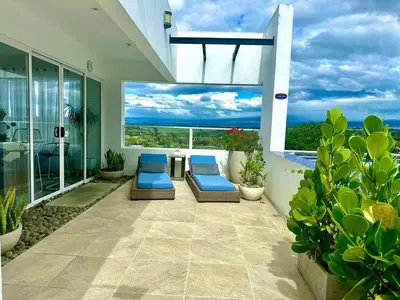 a balcony with two chairs and a view of the ocean at Luxury New apartment! Infinity Pool! Adults only in Tapantí