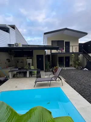 a house with a swimming pool in front of a house at Pelíkano Uvita in Uvita