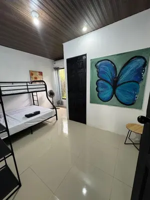 a bedroom with a blue butterfly painting on the wall at Pelíkano Uvita in Uvita