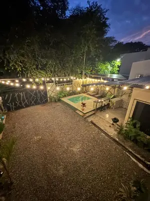a backyard at night with a pool and lights at Pelíkano Uvita in Uvita